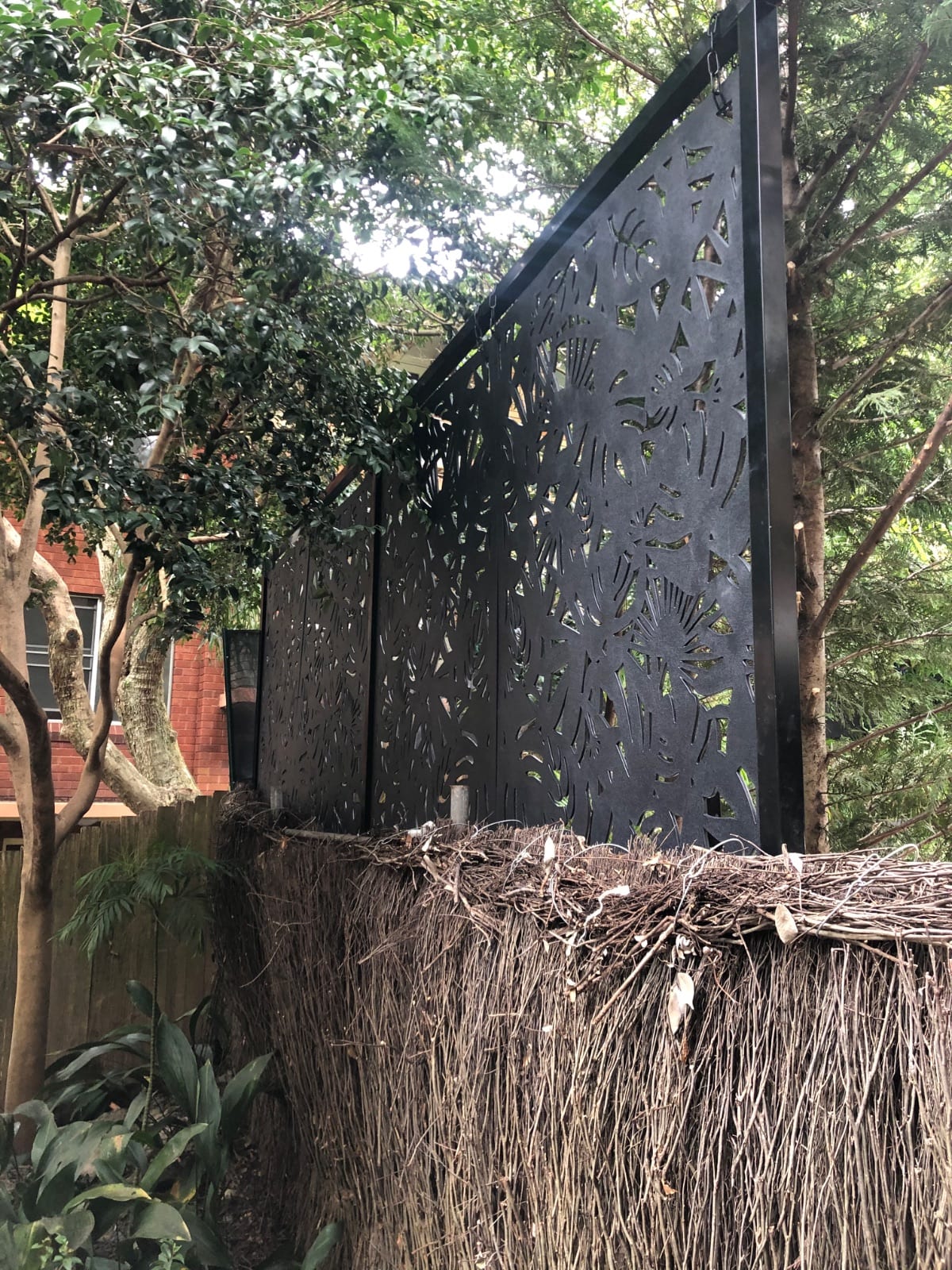 Decorative black privacy screen installed beside a pool in Wollstonecraft