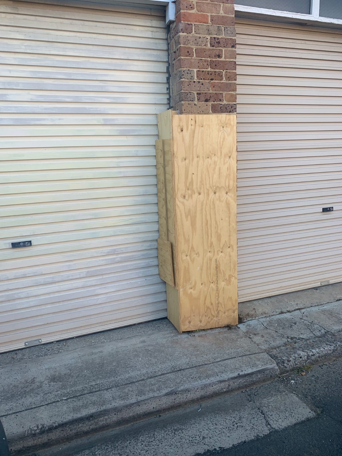 Plywood box surrounds fitted to the hit brick column at a strata block in Willoughby while the engineer assessed the structure