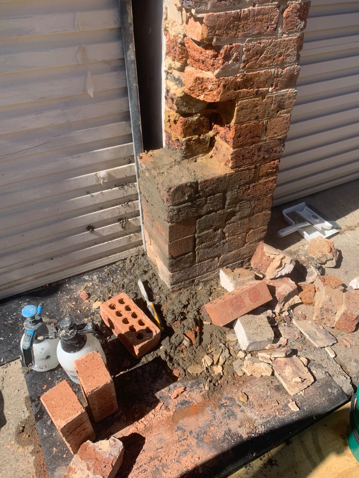 Brickwork being reinstated on the damaged column, a blend of salvaged and new bricks
