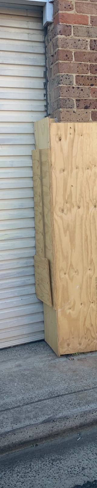 Plywood box surrounds fitted to the hit brick column at a strata block in Willoughby while the engineer assessed the structure